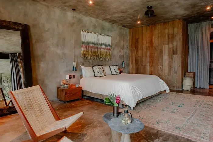 Fuego Suite at Nômade Tulum highlighting seating area with chairs and table, jungle view, and private pool.