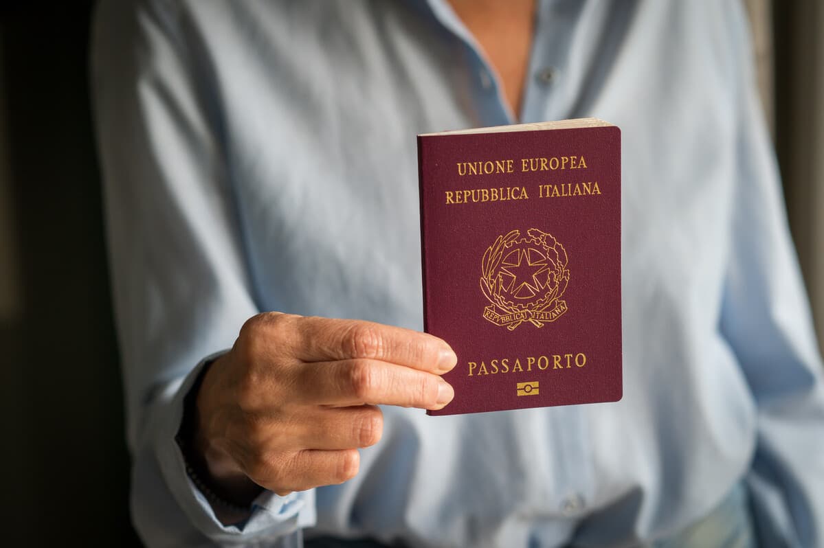 Mulher segurando passaporte italiano. Documentação para cidadania italiana: como erros podem travar seu processo