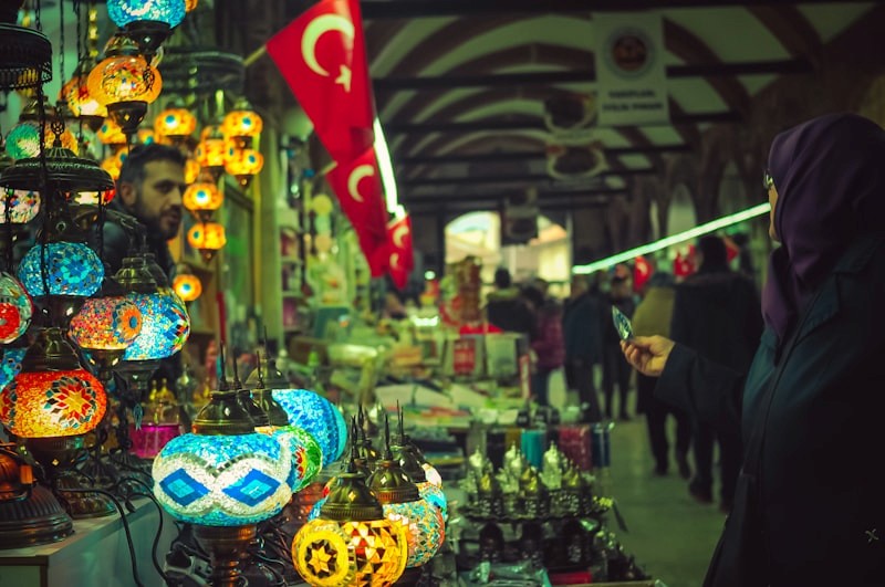 Kişi, Türk kültürel öğeleri veya pazarı görünür şekilde çevrimiçi alışveriş yapmak için dizüstü bilgisayar veya mobil cihaz kullanıyor