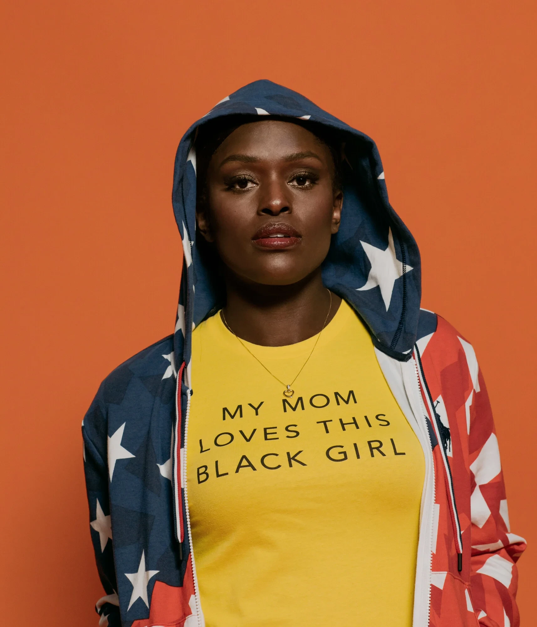 Aja Evans wrapped in an American flag wearing the My Mom Loves This Black Girl campaign shirt