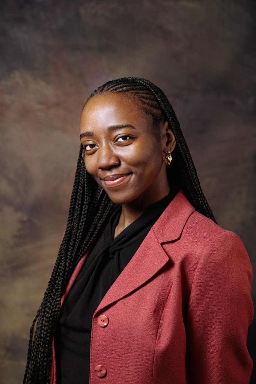 Professional headshot of a business advisor in a white shirt, smiling confidently against a warm neutral background.