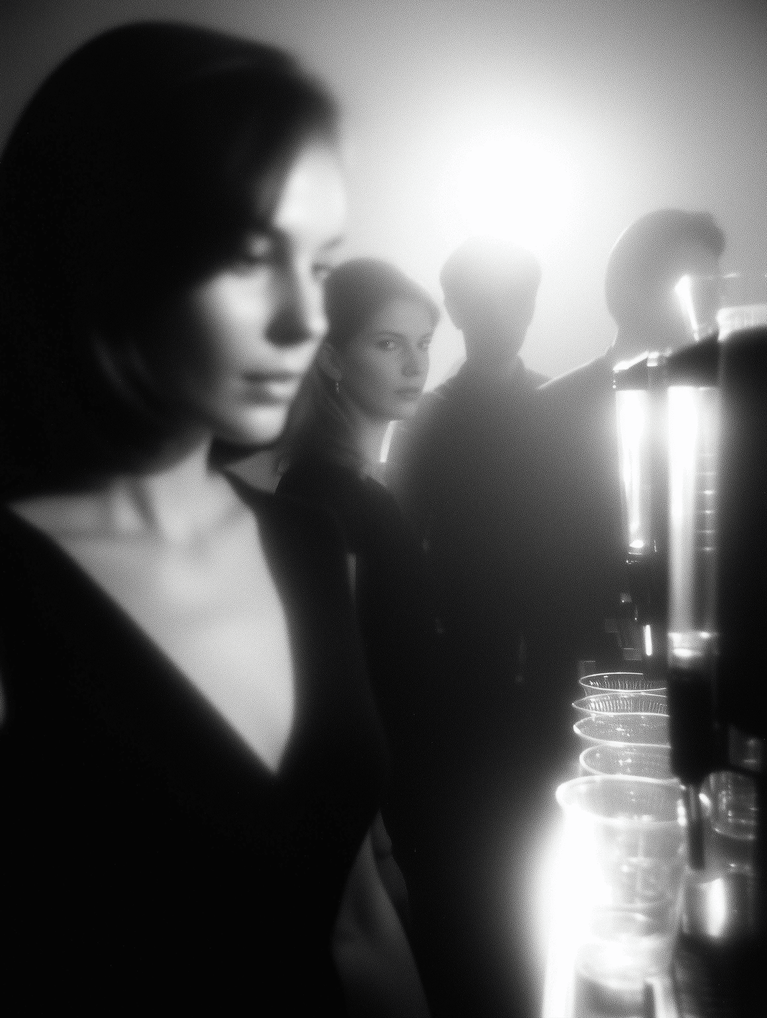 Woman in dark dress at a party with blurred people in background