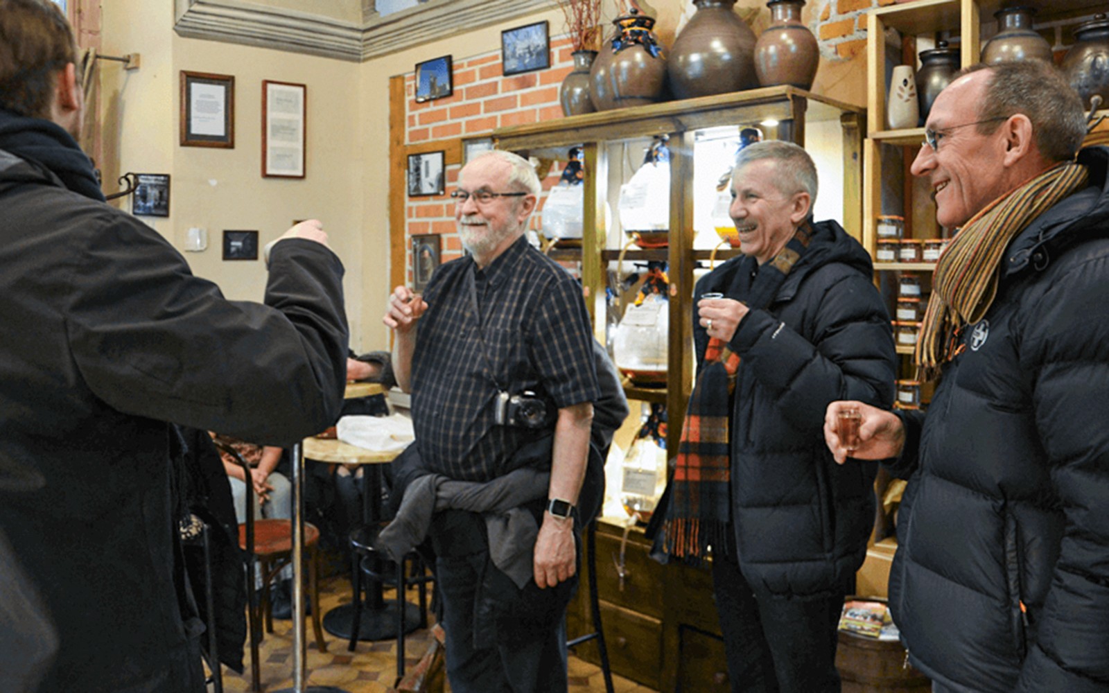 Grupo disfrutando de bebidas locales en un tour gastronómico callejero por Cracovia.