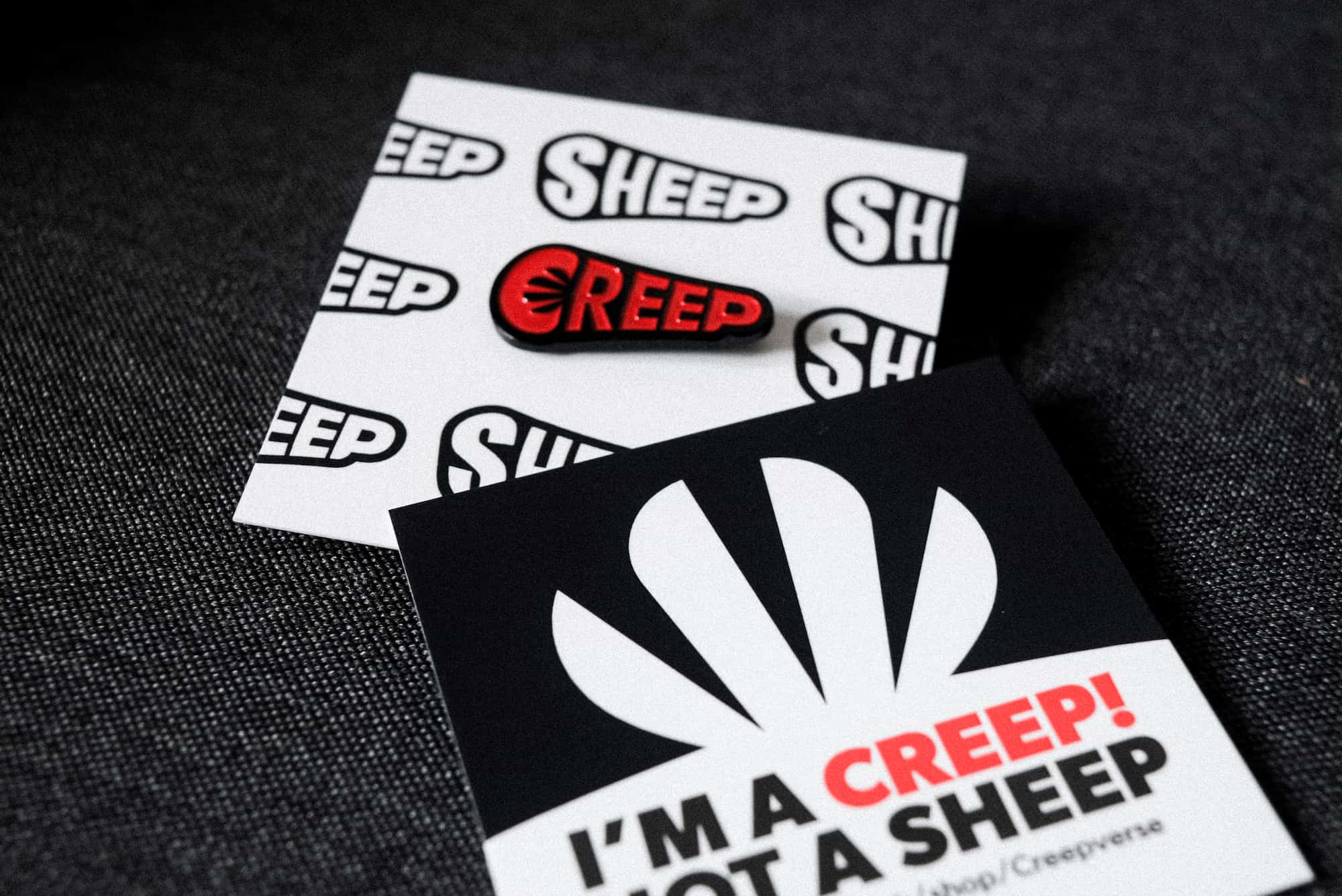 Creep enamel pin on backing, branded with creep idenity.