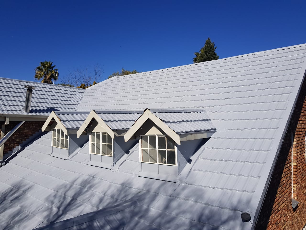 House roof getting sprayed with waterproofiing rubber