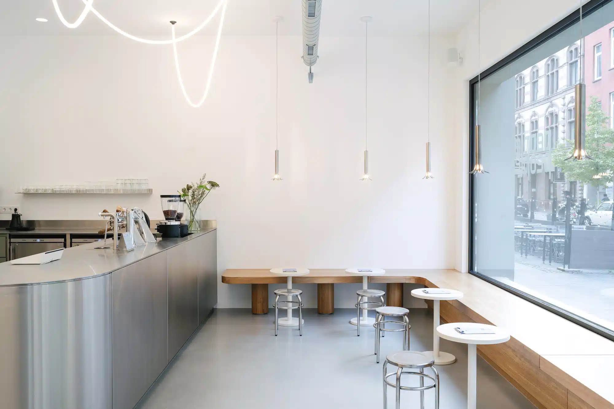 Reforma – bright minimalist interior with coffee counter, seating area and large window front overlooking the cityscape