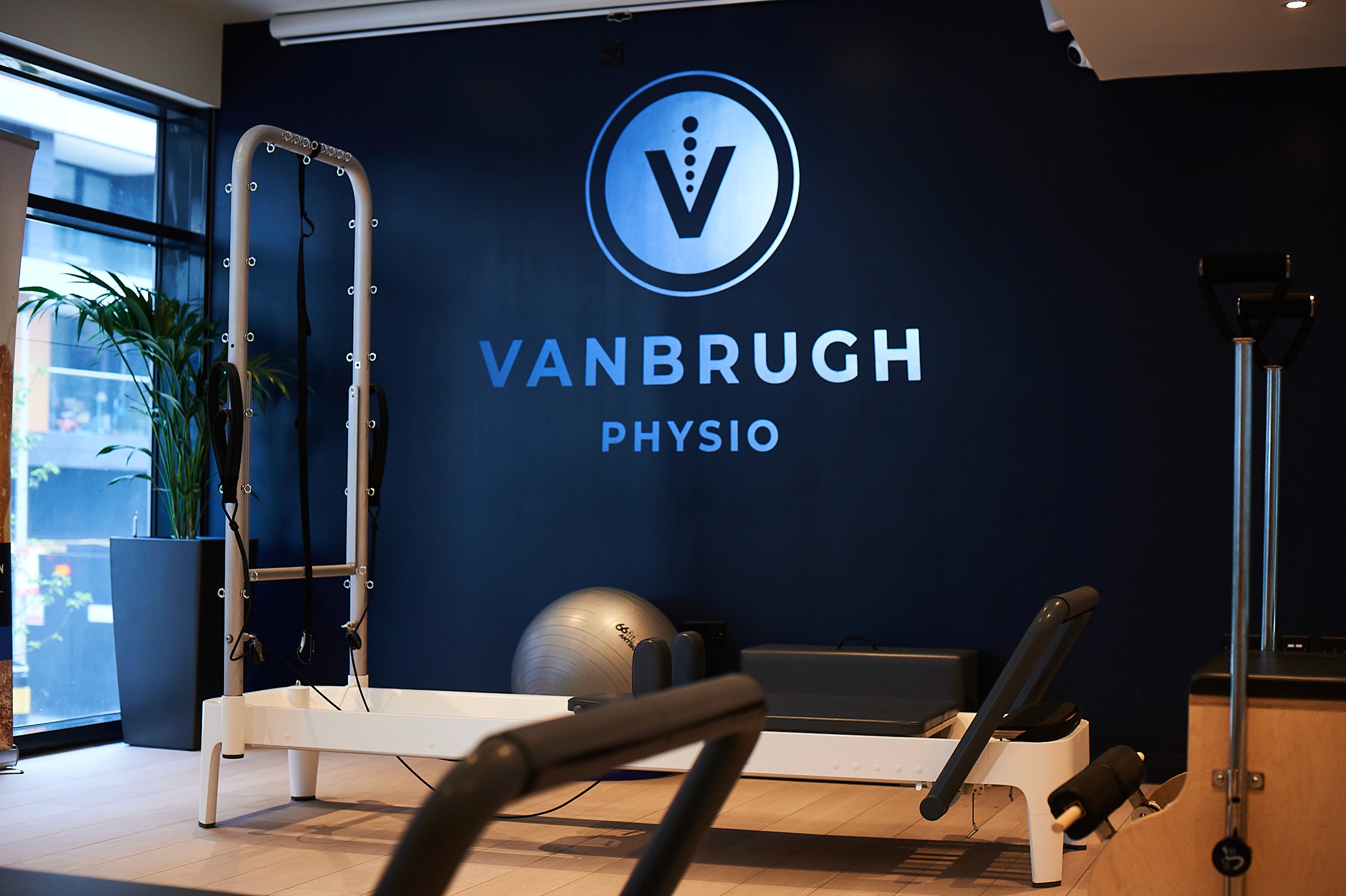 Vanbrugh Physio London pilates clinic wall displaying logo