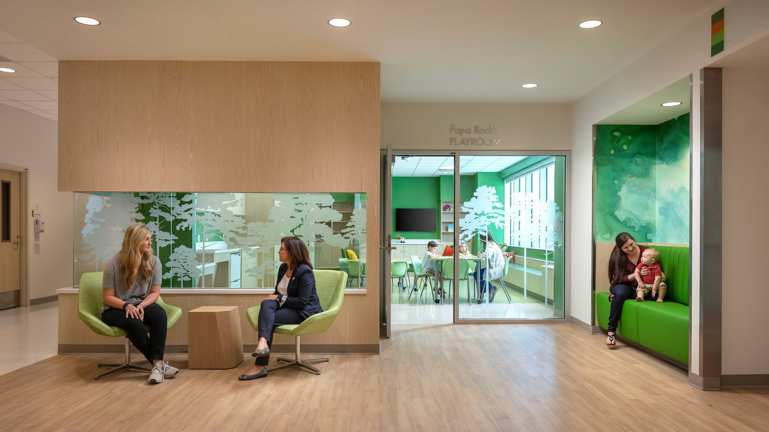 Waiting area with playroom and seated people.