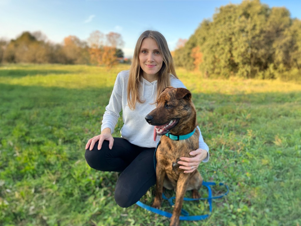 Vidya Torres et son chien Soba assis dans l'herbe