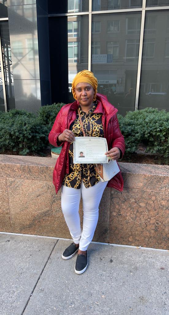 Ecstatic individual holding U.S. flag after naturalization, aided by Fibi Law