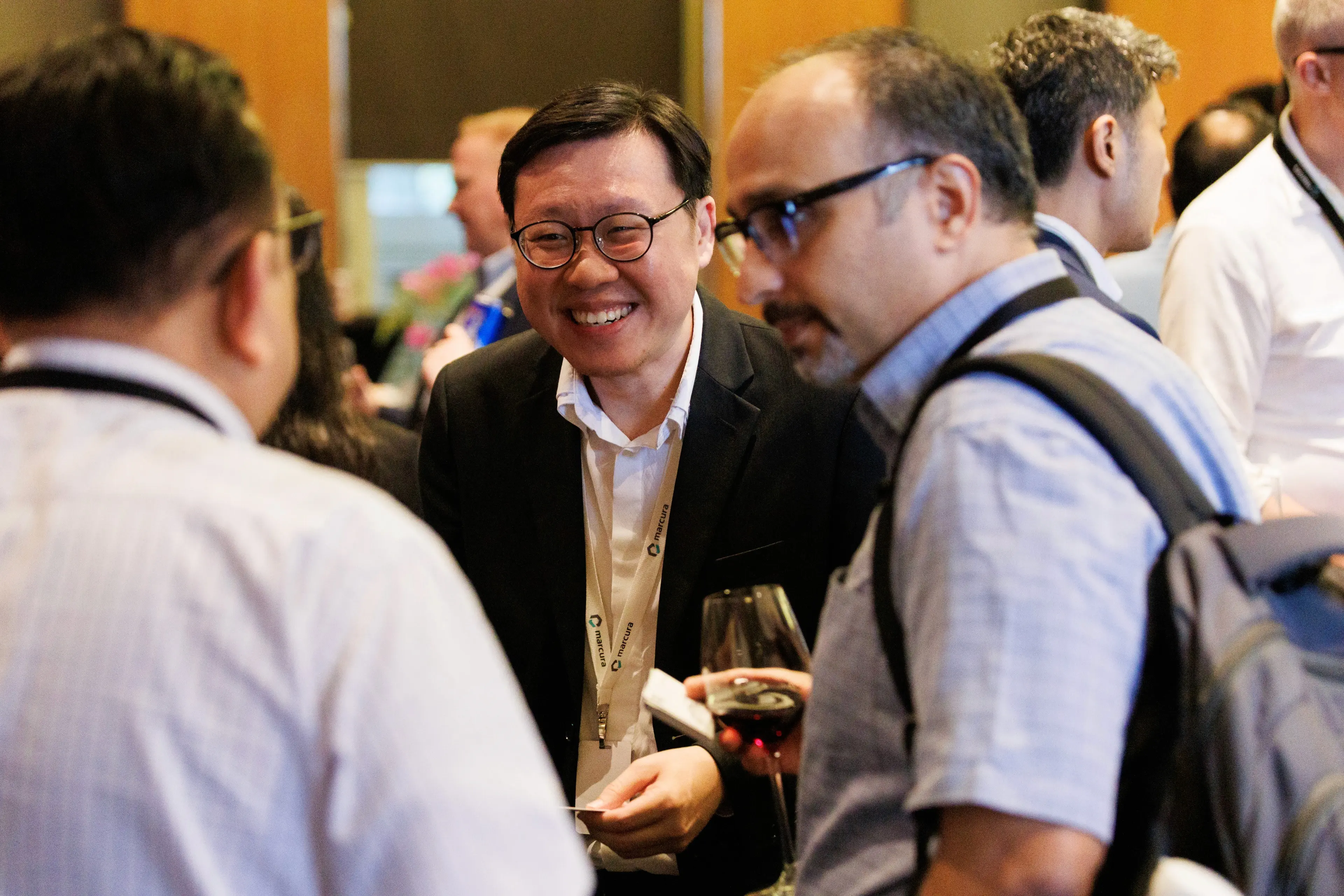 A group of people conversing in a professional setting, engaged in discussion and networking.