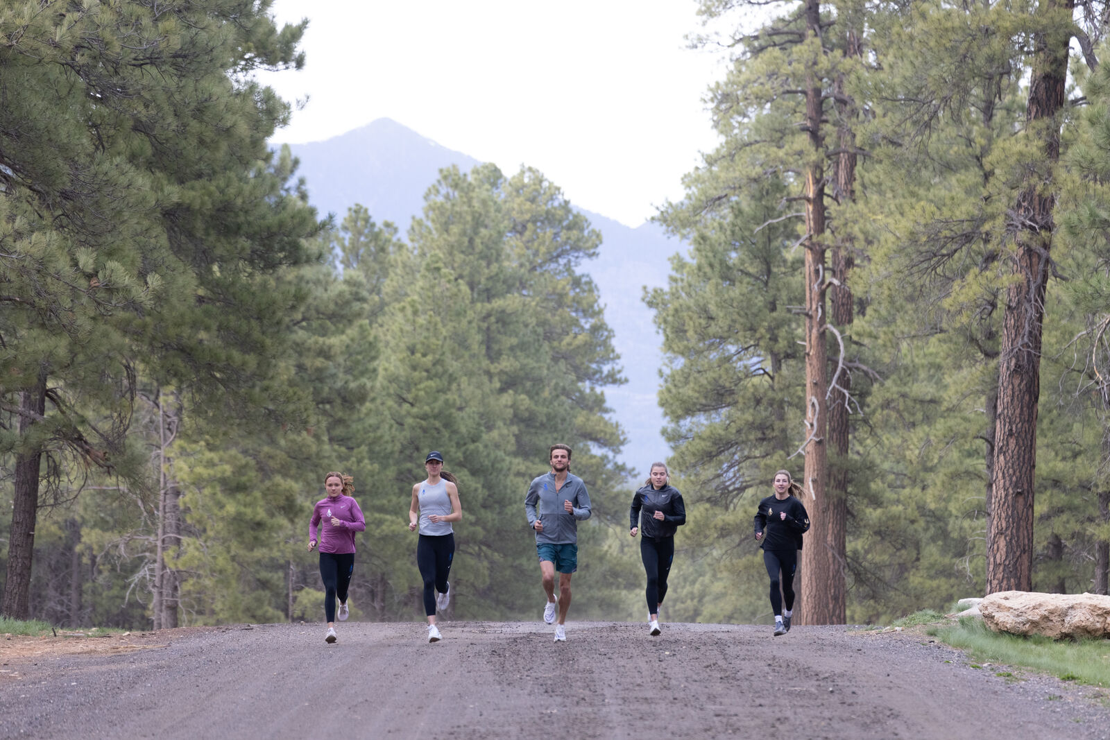 Nike shoot, five runners on a forest road under the mountain