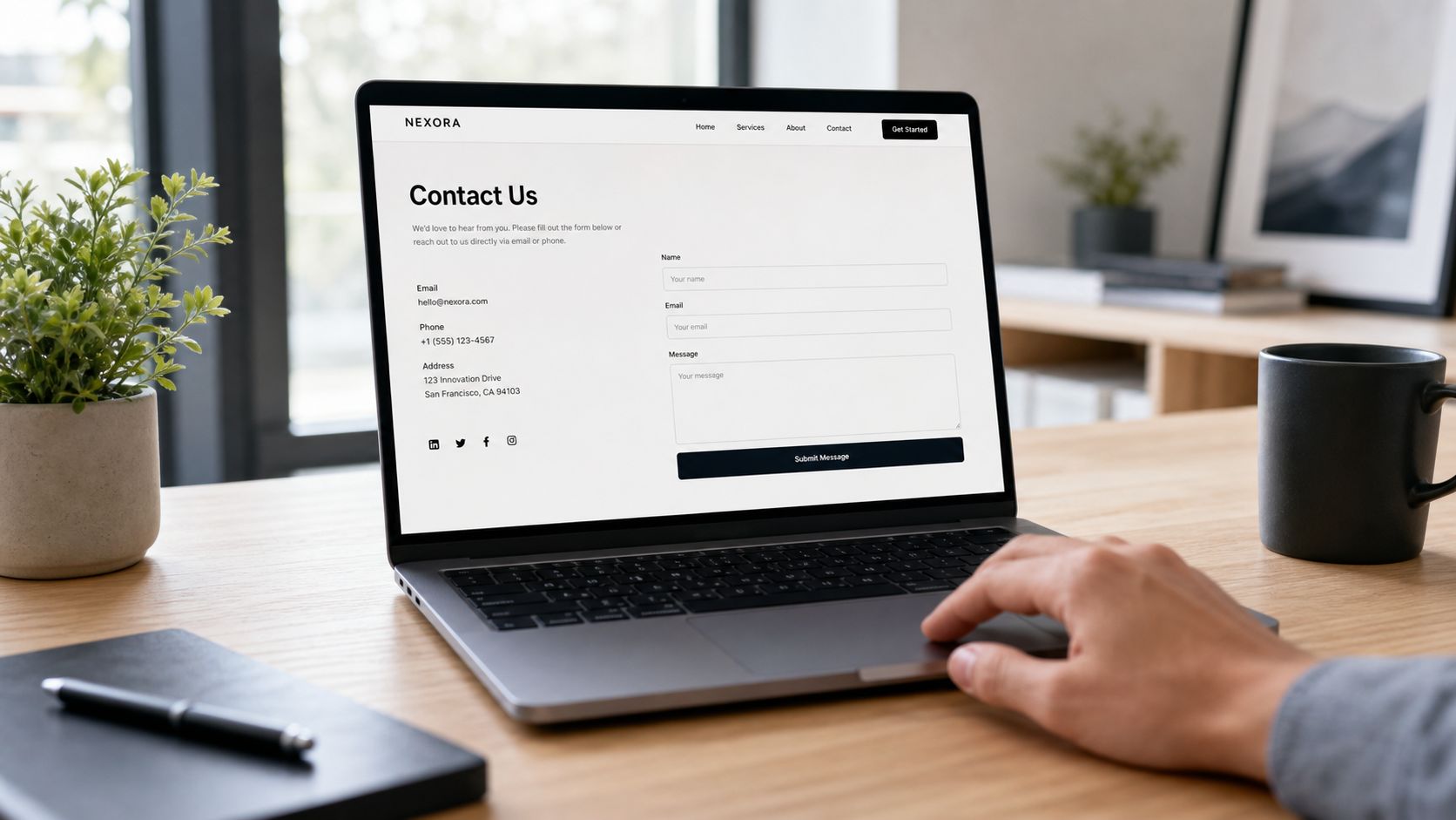 A person using a laptop to view a professional website contact form in a modern office.