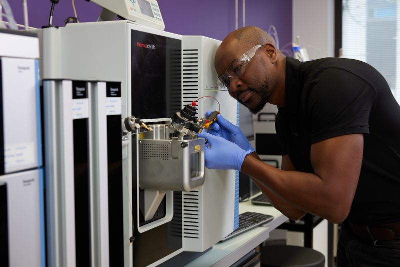 Technician repairing a Thermo Fisher Scientific instrument.