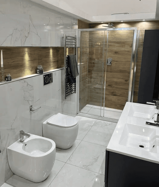 Bagno molto elegante rifinito con rivestimenti in marmo e box doccia in cristallo