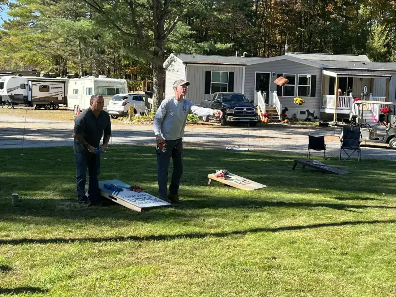 Guests playing a game of cornhole on the lawn at Pine Hollow Campground, a top-rated choice for campgrounds in Southern VT near Bennington.