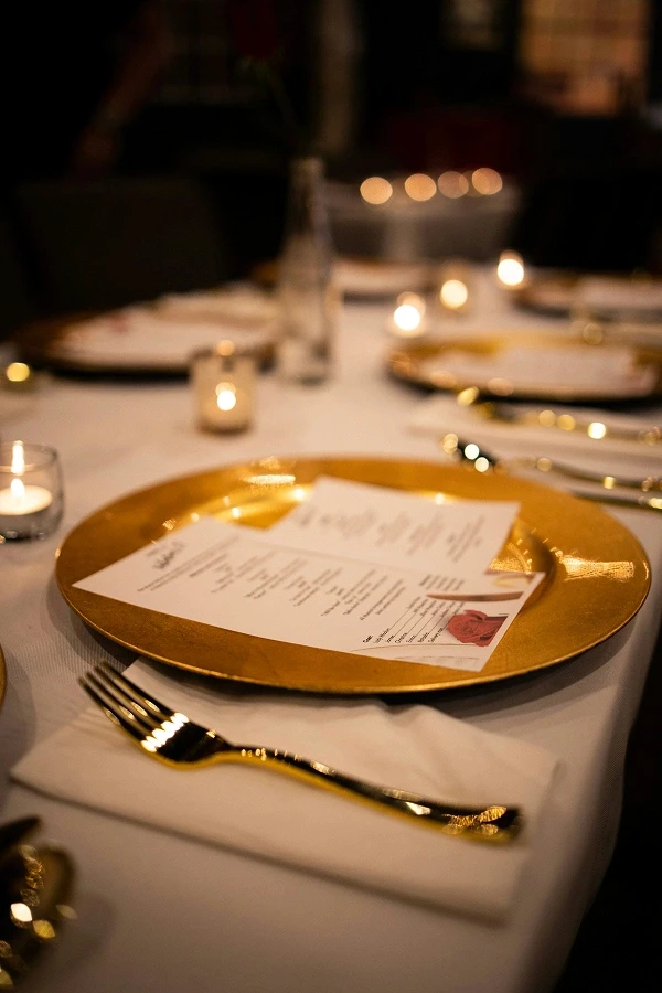 Elegant wedding reception table with candles and gold place settings