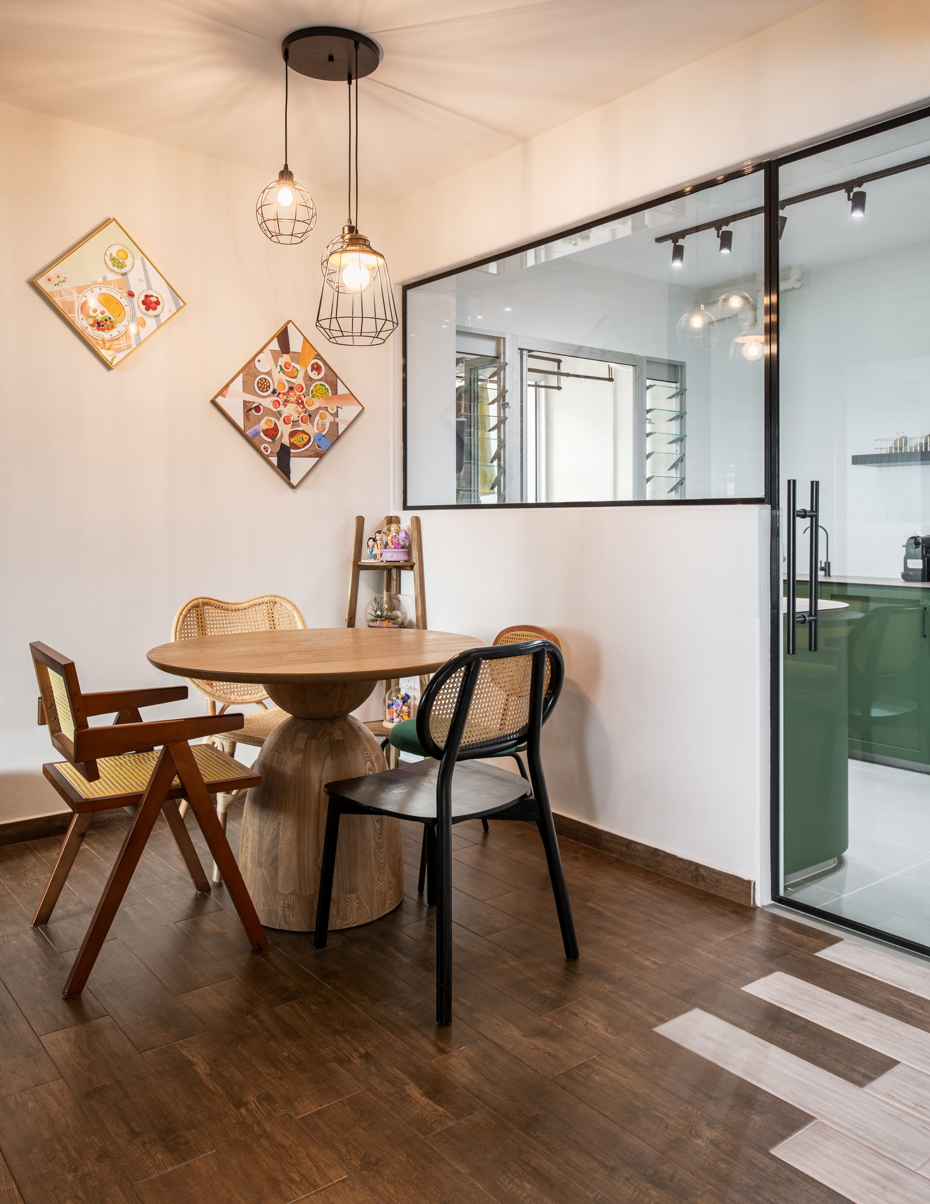 Cozy dining nook with a round wooden table, mixed chair styles, and warm pendant lighting, creating an inviting atmosphere for family meals.