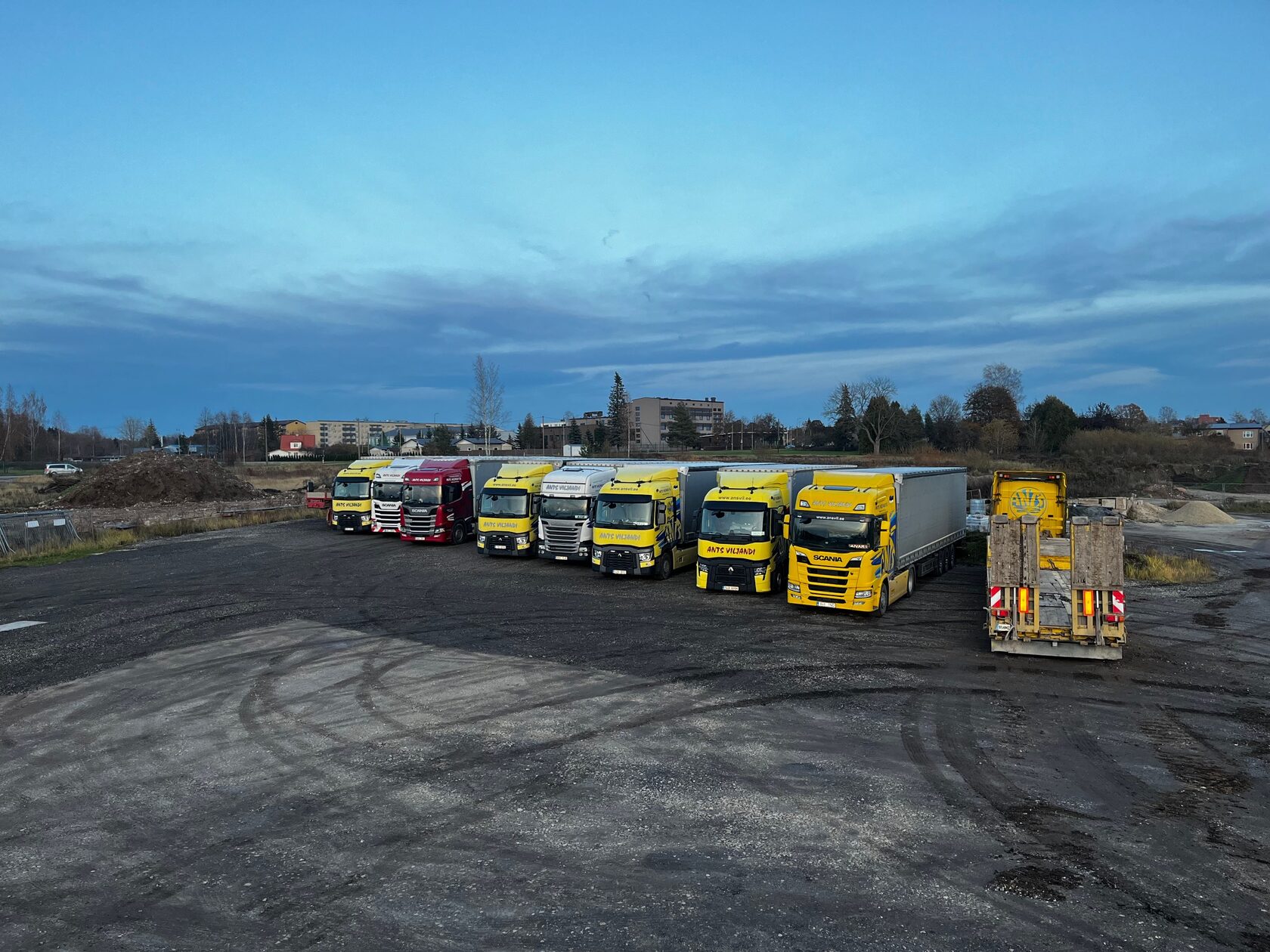 Yellow Ants Viljandi trucks parked in a row at dusk