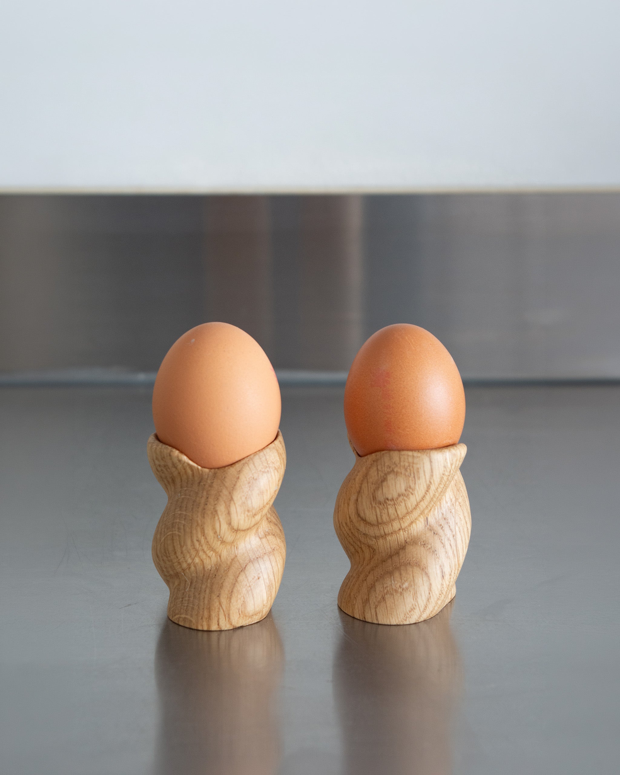 99 Egg Cup pair in Oak by Wilkinson & Rivera onsteel countertop