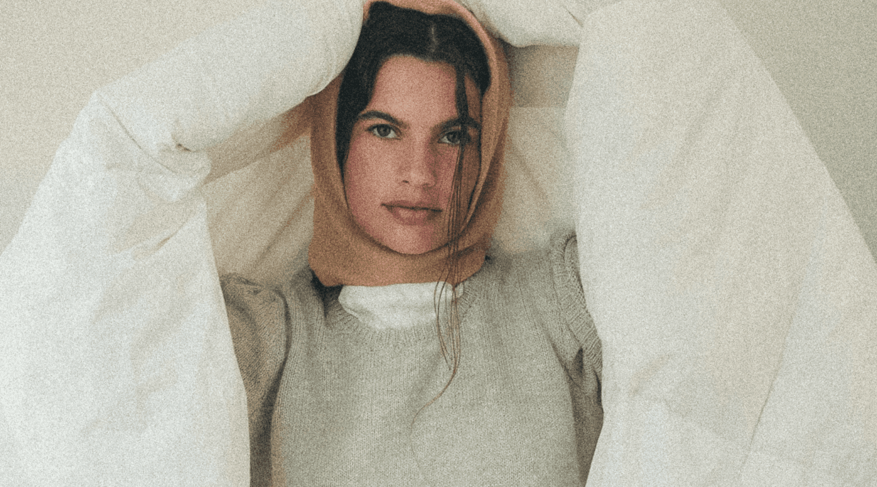 A person in business attire lies amidst scattered papers and folders on a red carpet, holding a phone receiver. The scene conveys chaos and stress.