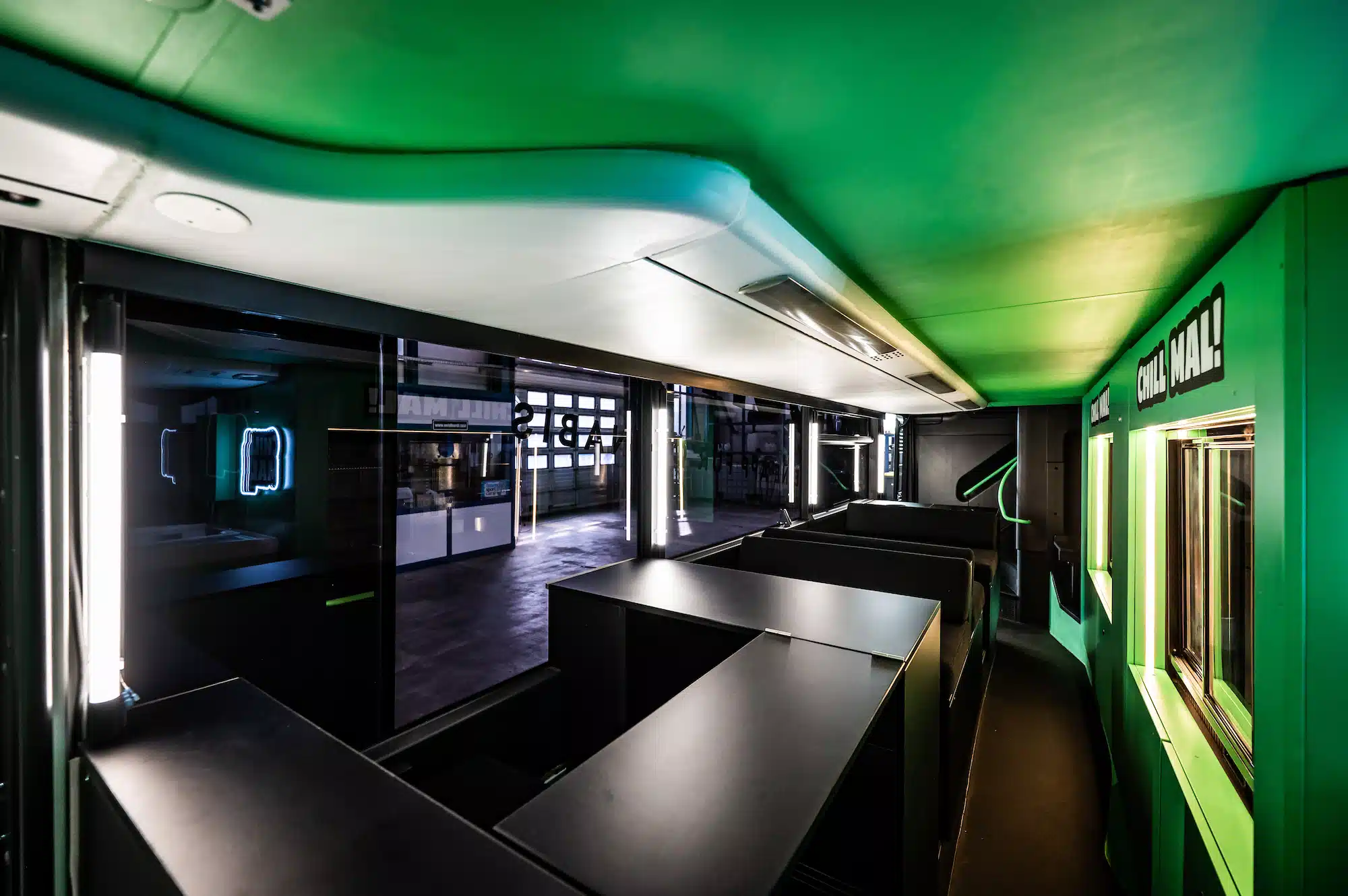 Bloomwell Cannabis App – ground floor of the bus interior with green neon ceiling and distinctive brand design