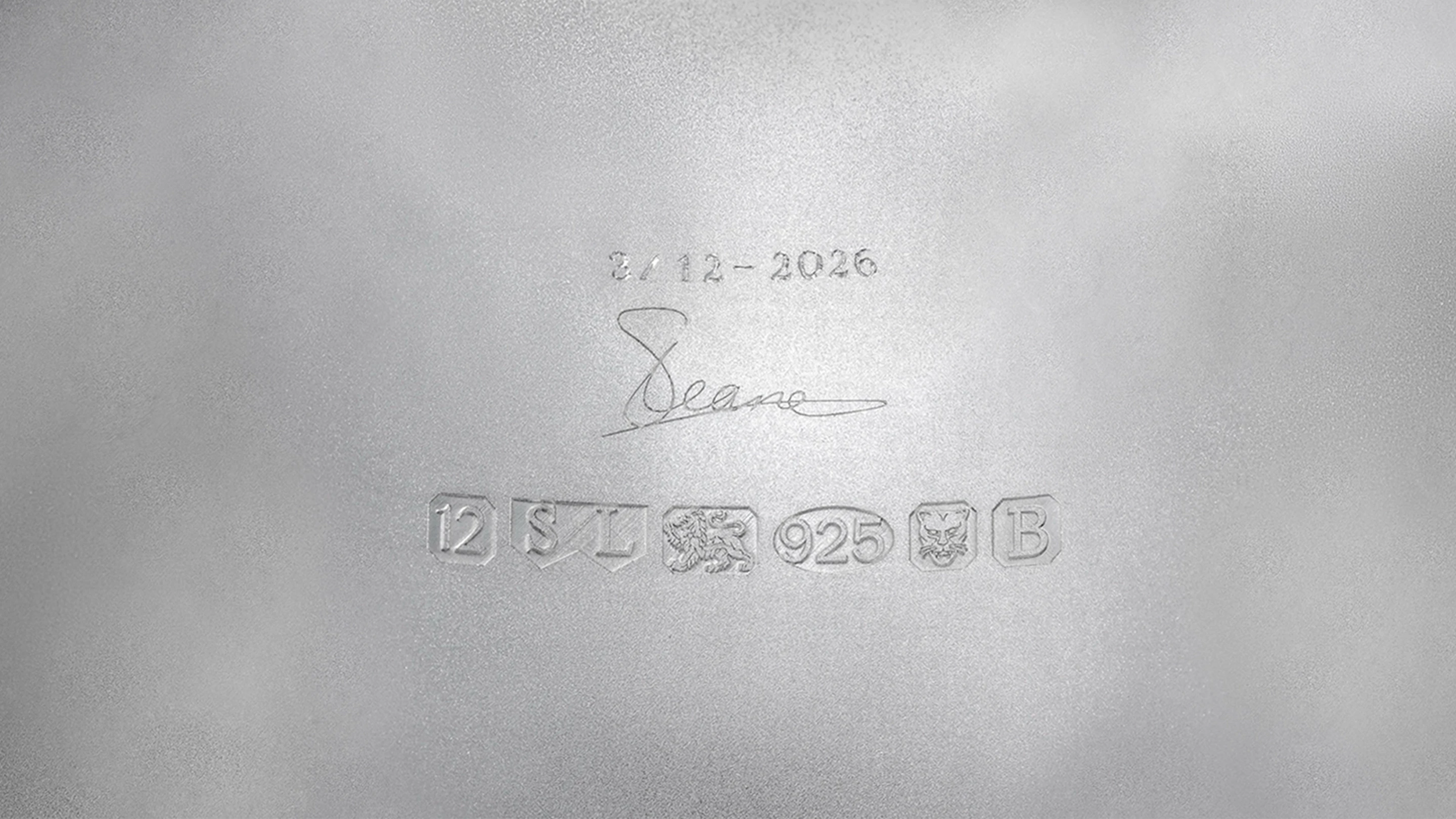 Macro detail shot highlighting the intricate hand-engraved patterns on the polished surface of the Shaun Leane silver neck collar.
