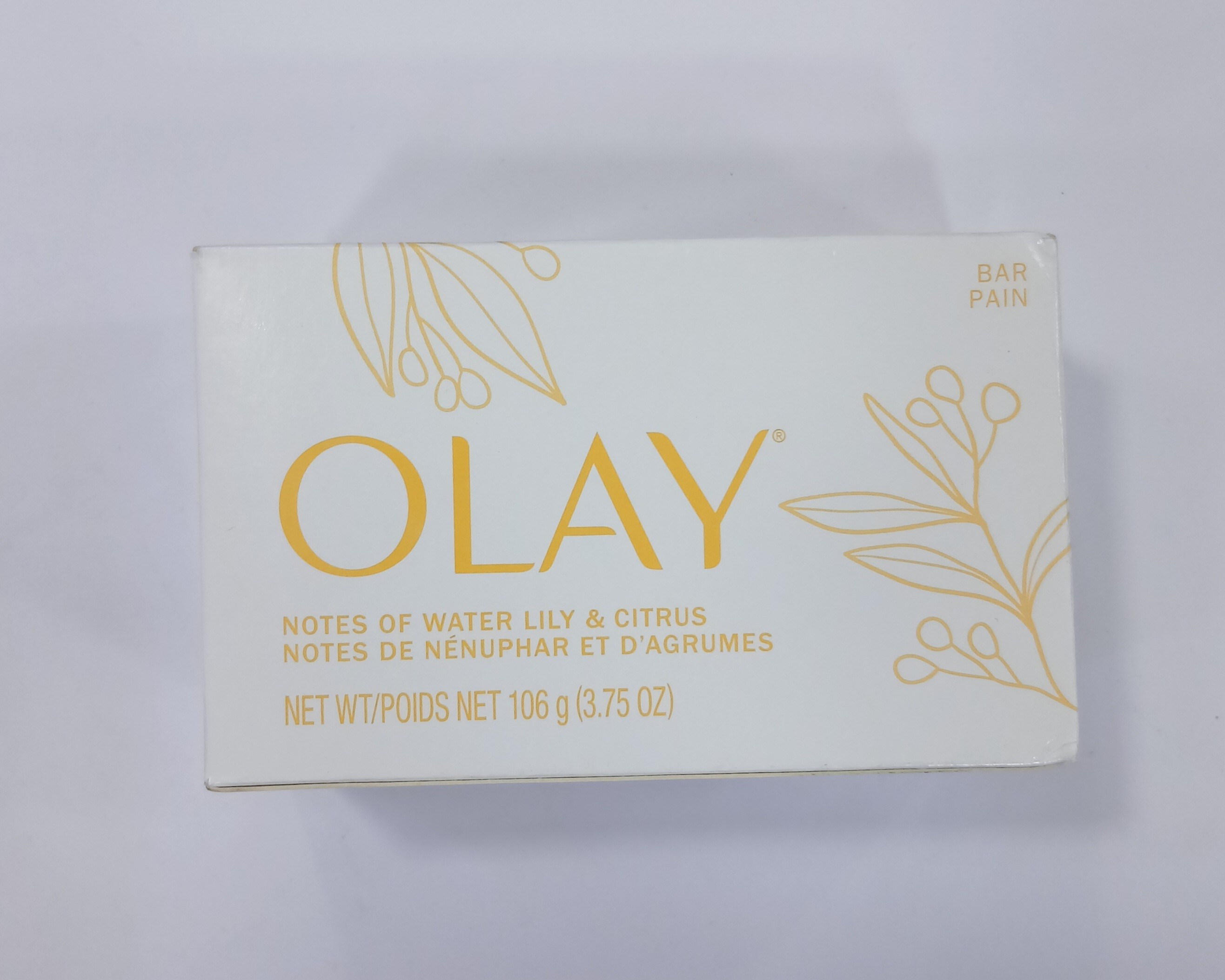 White rectangular cardboard box packaging for bar soap displays gold-toned text and illustrations of water lilies and citrus leaves on a light background.