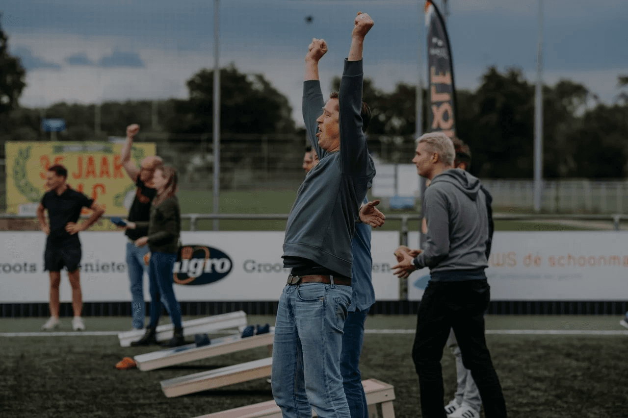 Man throwing beanbag during cornhole tournament at sports day in Amsterdam