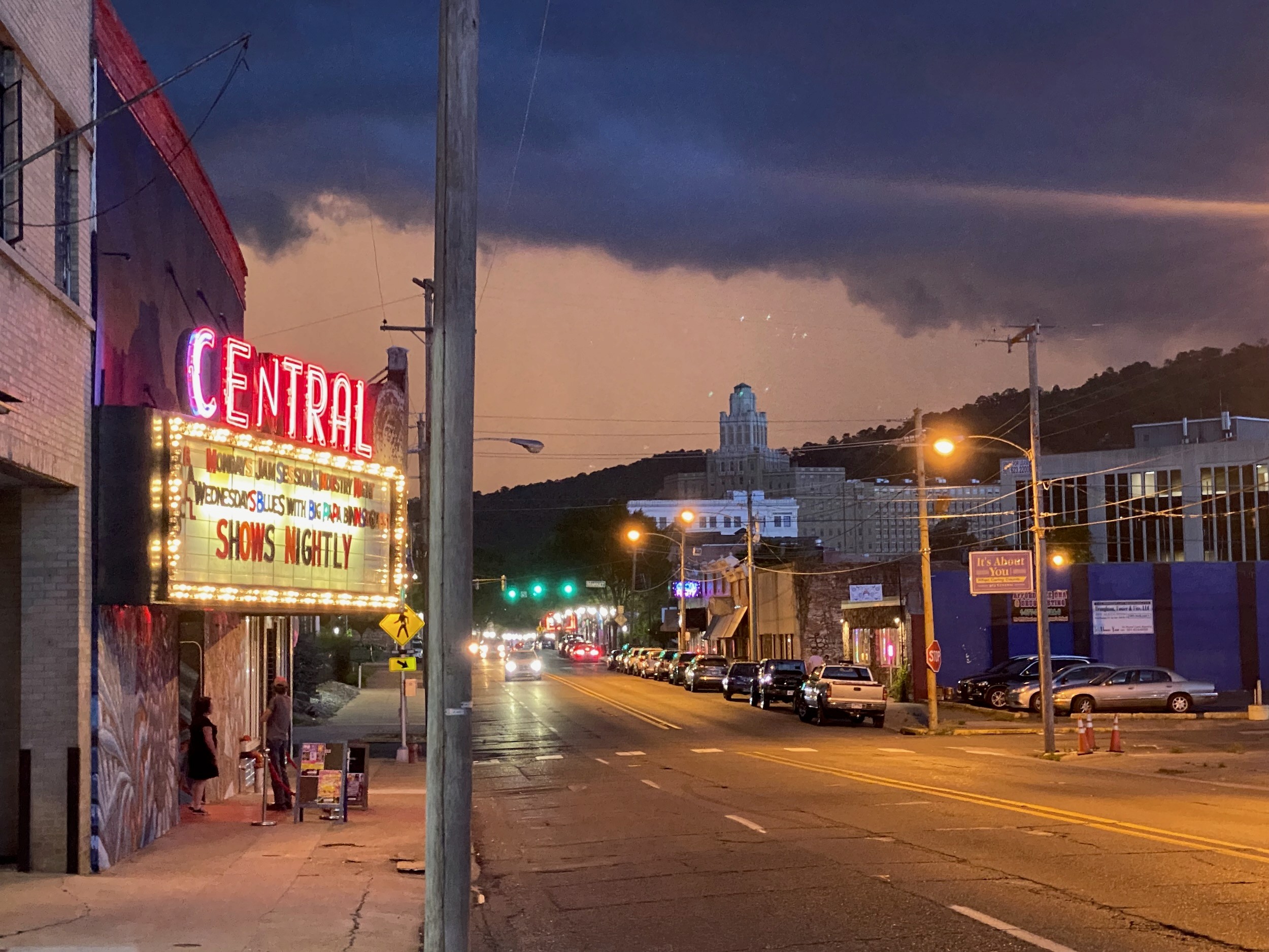 At dusk, the lit “Central” marquee reads “Shows Nightly” on a quiet street beneath storm clouds.