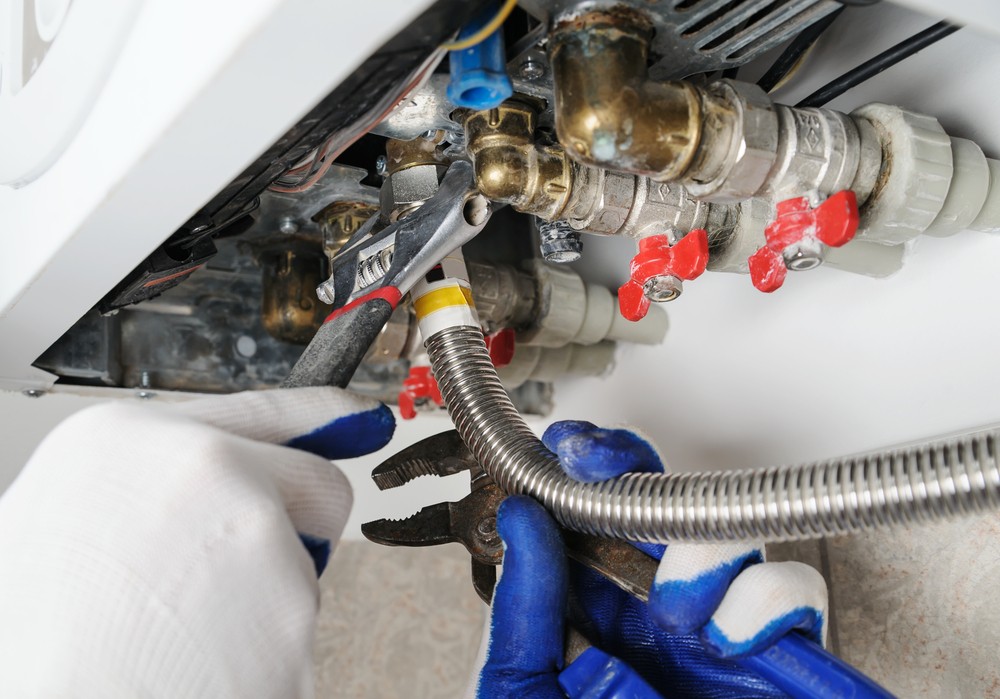 The underside of a boiler, an engineer is removing the boiler 