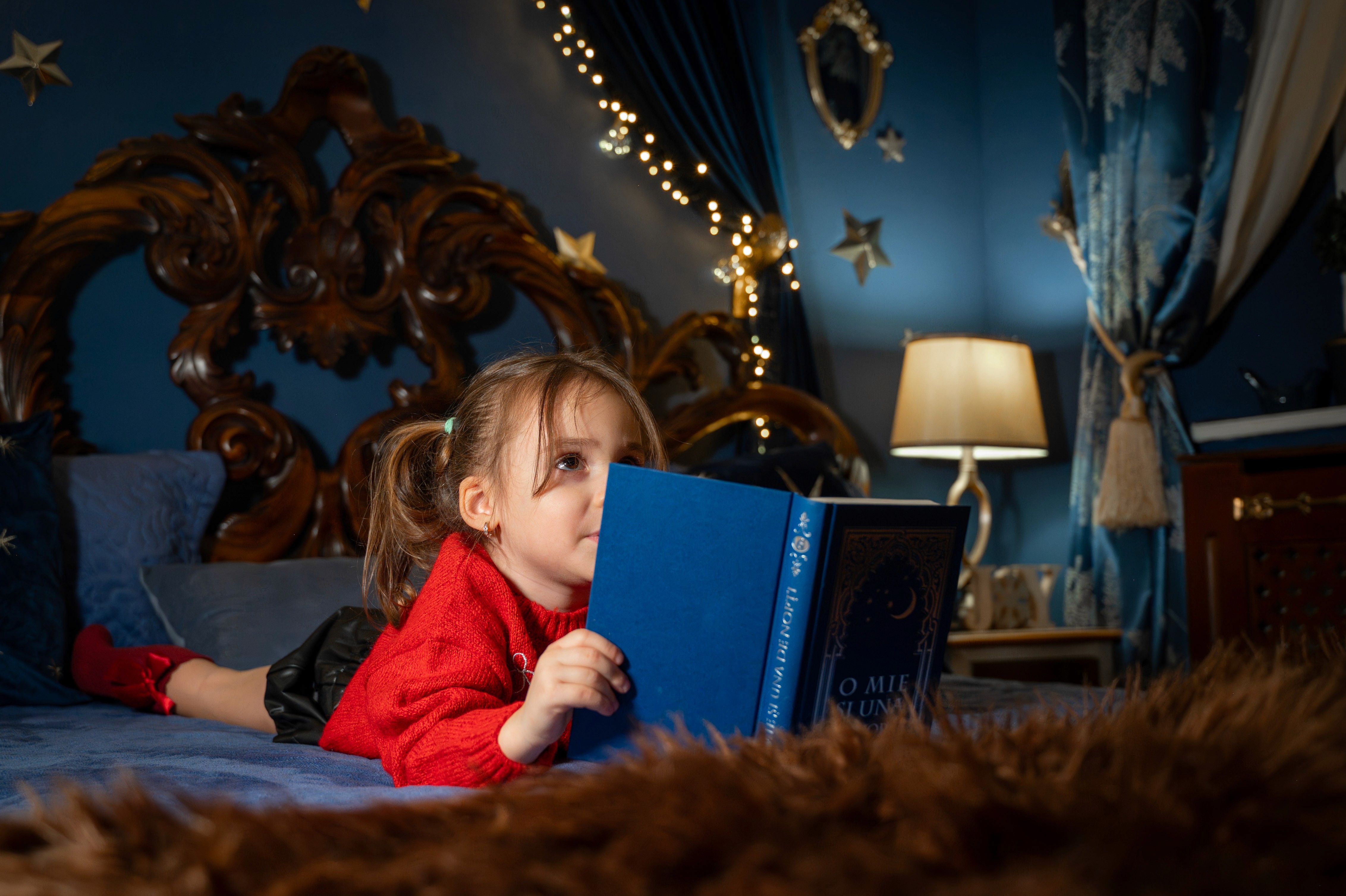 Fotografii de Crăciun cu copil citind o carte, cadru cald și atmosferă magică