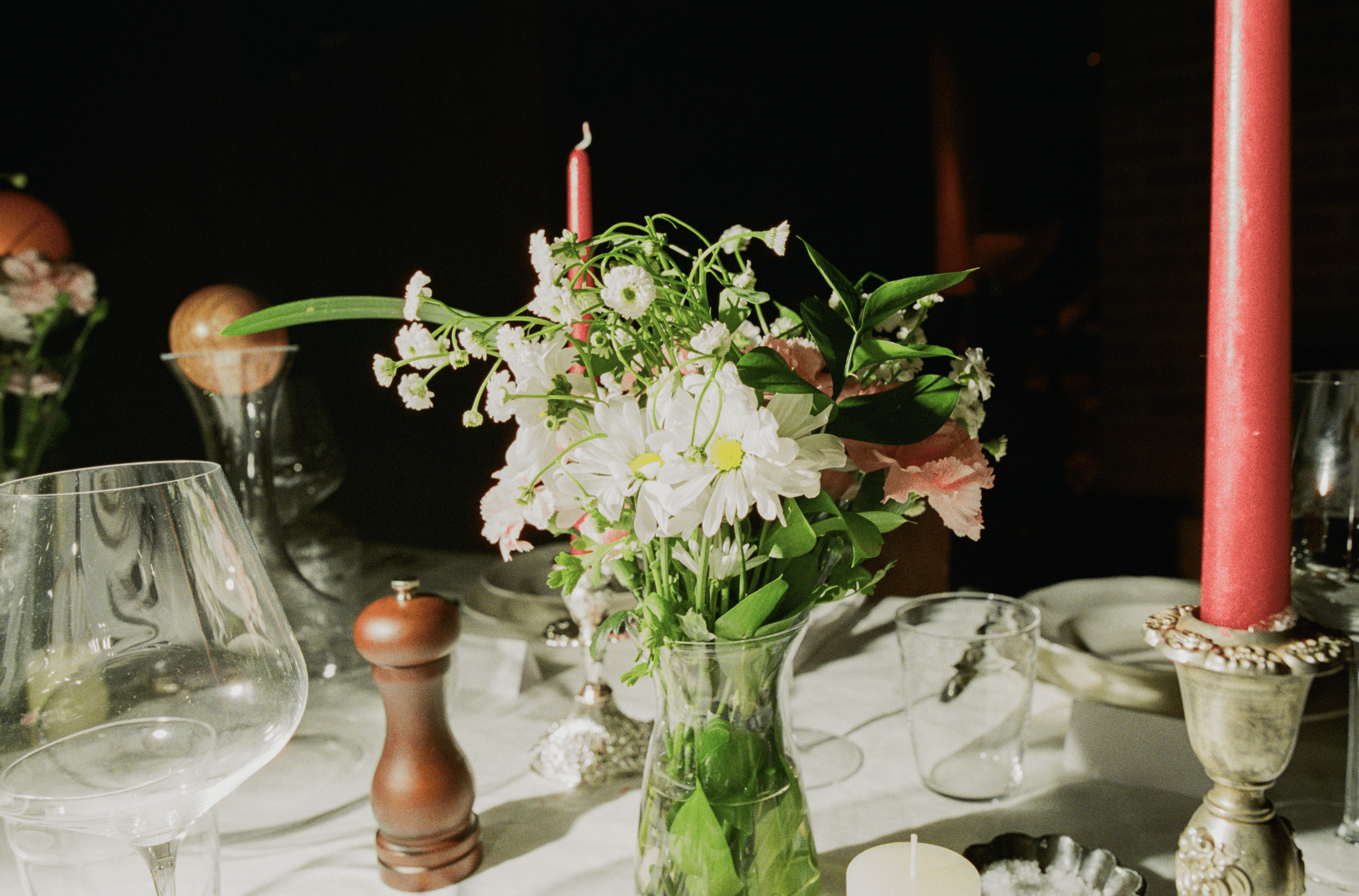 A decorative floral arrangement spills over a table draped in red fabric, creating an elegant atmosphere.