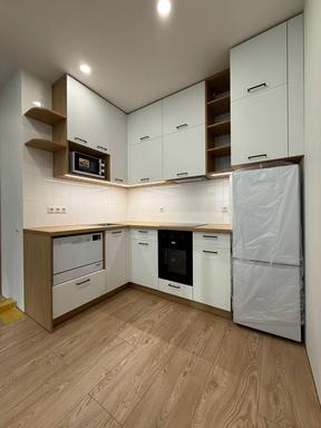 Smiling woman in a white shirt against a soft teal background, professional portrait.