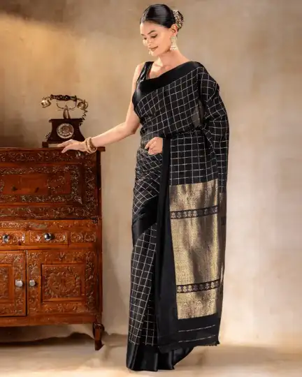 A woman wearing a black crepe saree with delicate golden borders from That Saree Shop, highlighting the saree’s fluid drape and refined craftsmanship for an elegant, modern look.