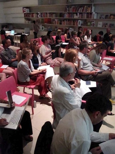 a crowd in a pink chair with handouts