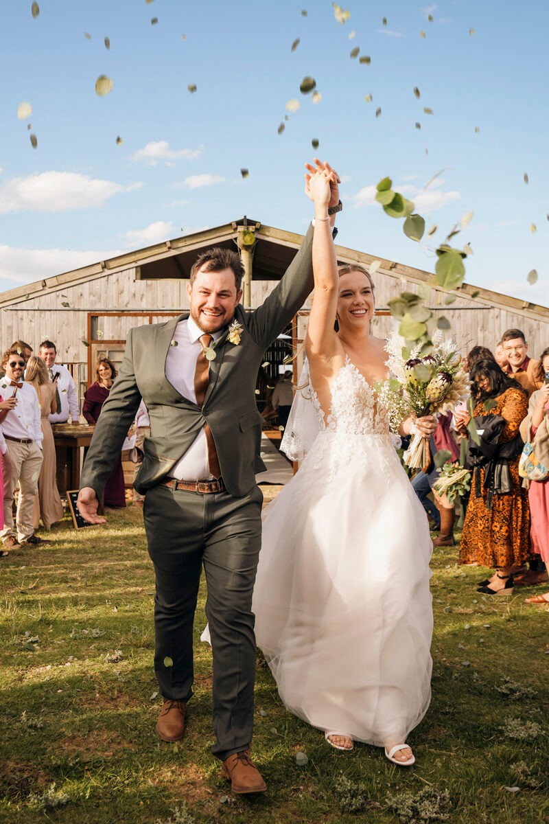 Bride and groom celebrating as confetti is thrown after ceremony