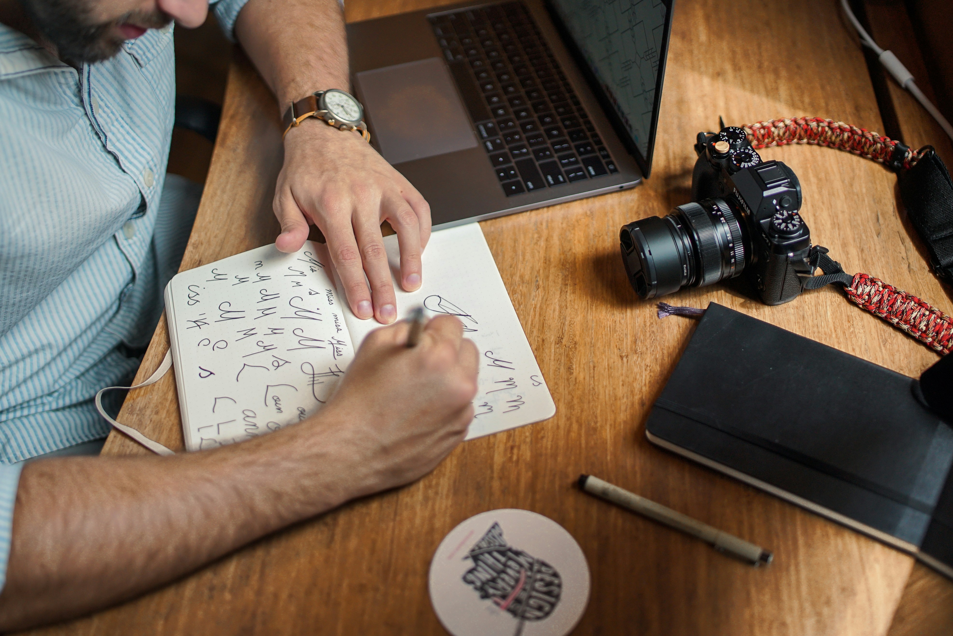 Photo d'un bureau sur laquelle on voit un graphiste travailler