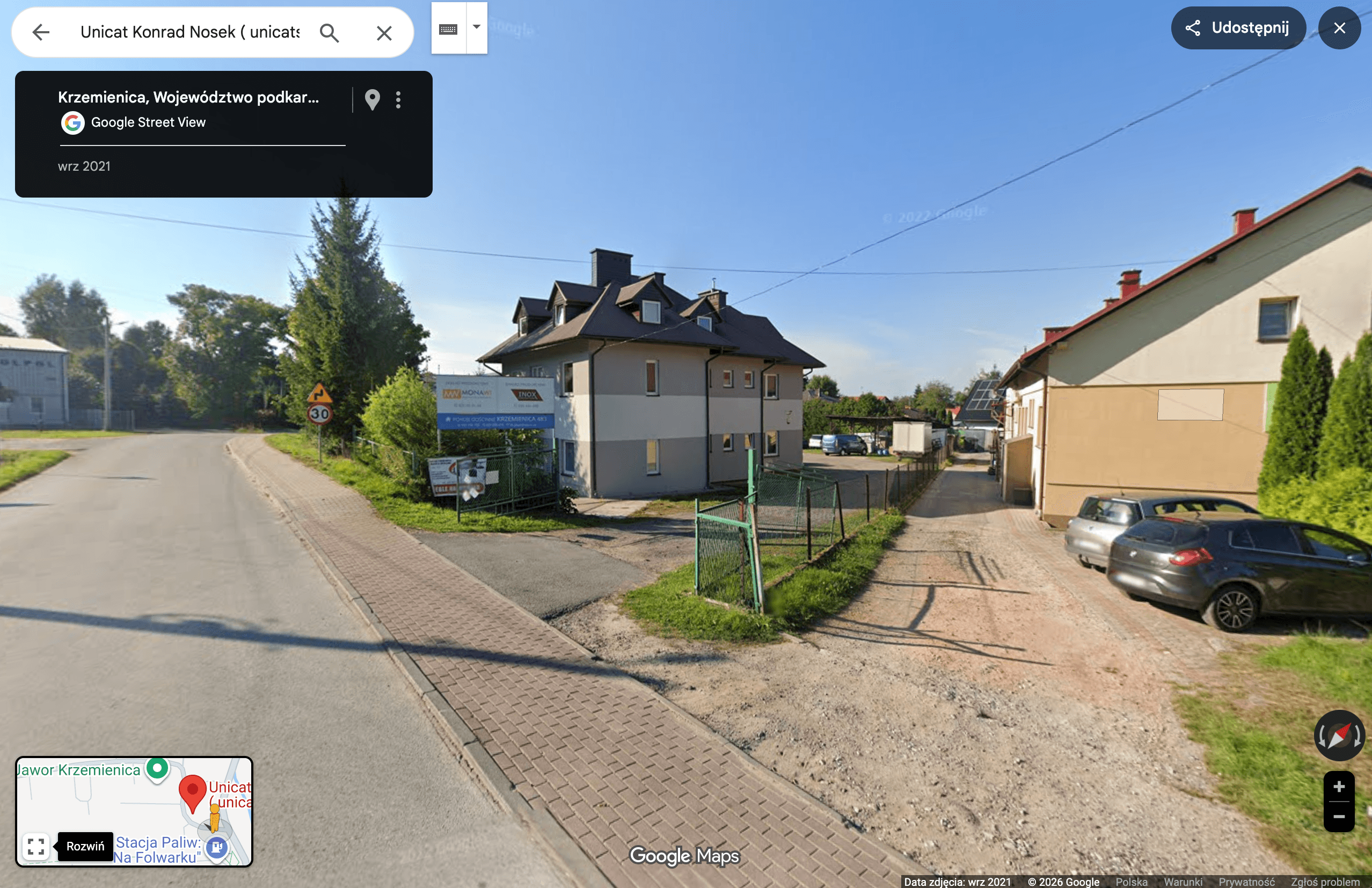 Restored brick building with arched windows and modern glass storefront on a quiet street
