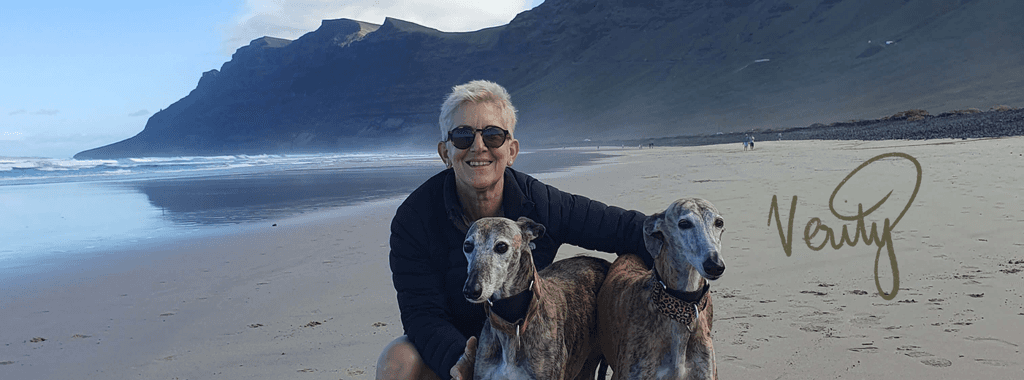 Image of Verity Harrison, illustrator from Inky Thinking on the beach with her dogs
