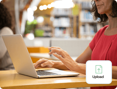 Person using a laptop to upload a file, with a floating “Upload” icon symbolising document management and digital record storage.