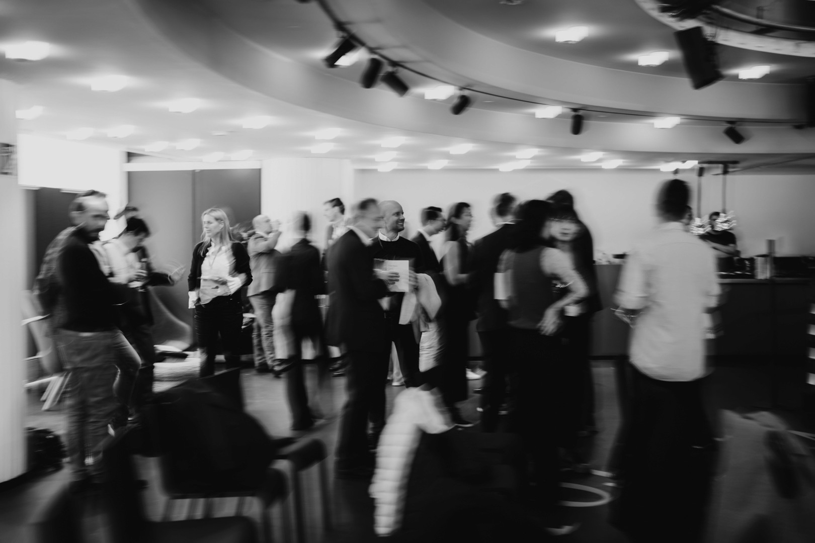 Indoor event with many businesspeople in motion, capturing dynamic movement