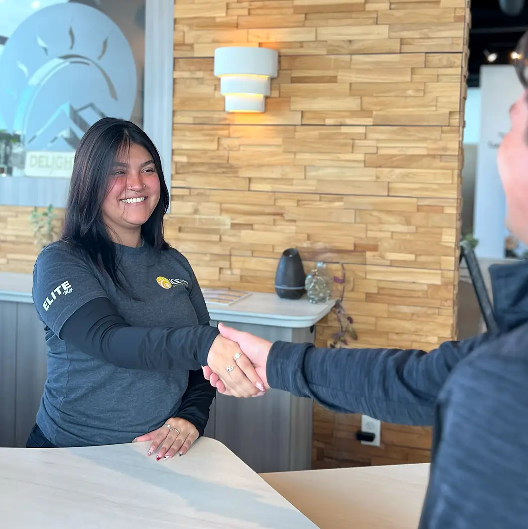 Receptionist greeting patient as they walk into Wellness clinic.