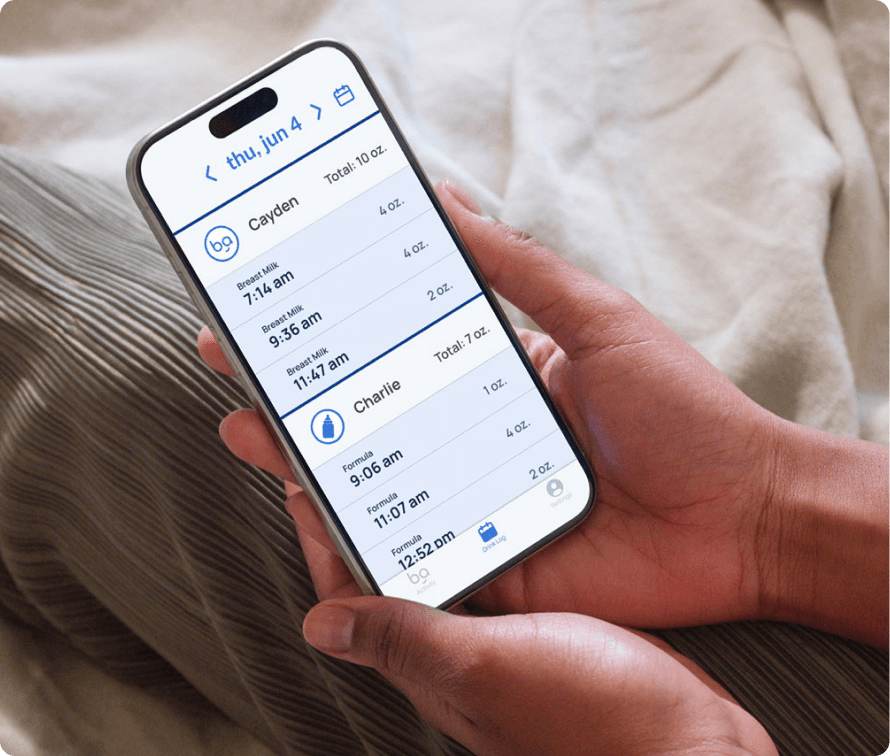 Person holding a smartphone displaying a feeding log on an app, showing detailed entries for tracking baby feeding times and amounts.