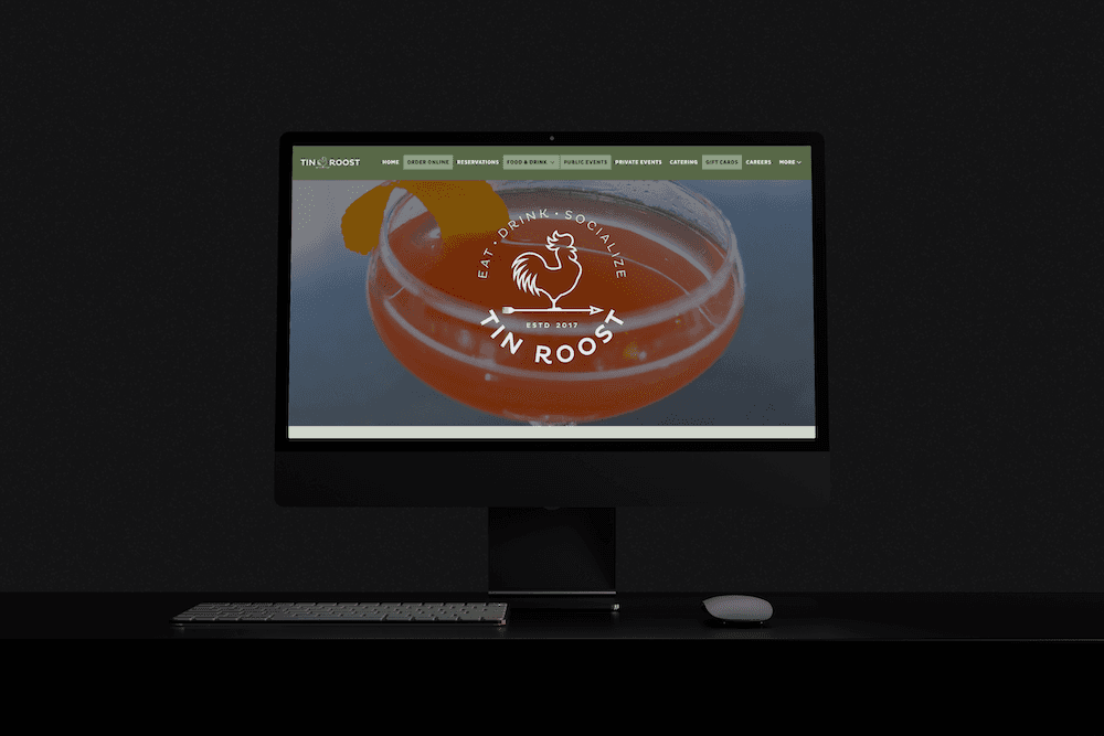 a desktop computer in a dark room with a restaurant website displayed