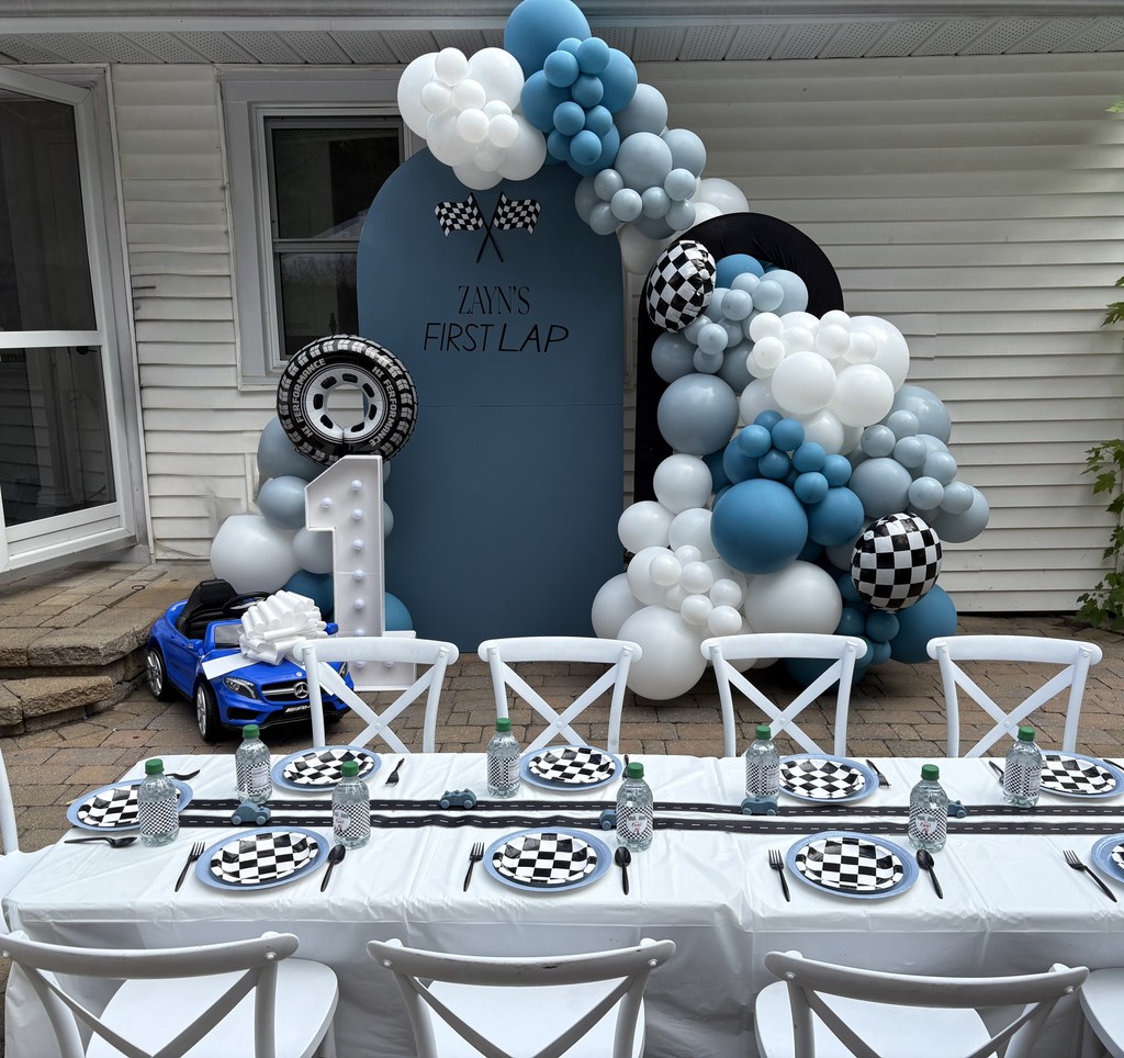 Balloon arch with big 15 inch balloons and 7 inch ballloons in the colours black, purple and blue. The arch is black and has happy birthday sign. The theme is based out of fortnite video game.