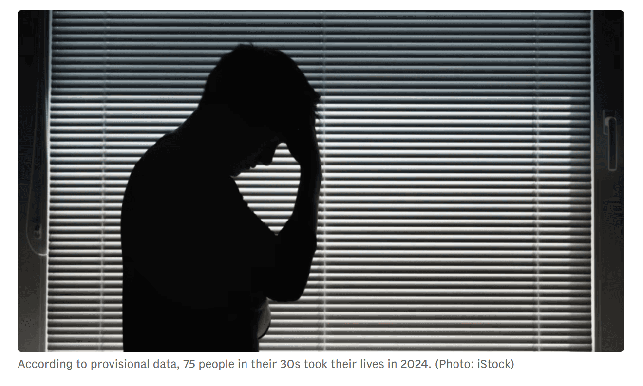 person in gray hoodie holding red and white box