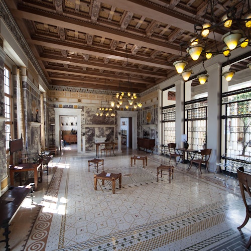 華麗的房間，地板鋪有瓷磚，天花板是木製的，吊燈和大窗戶。裝飾包括古典圖案和古董家具。
