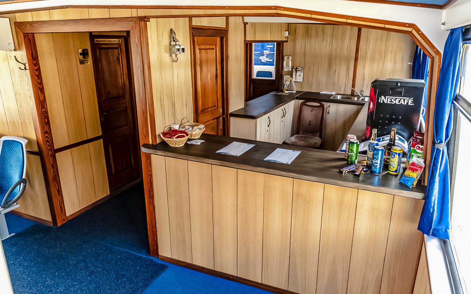 Innenraum eines Donaukreuzfahrtschiffs mit einem Snackbereich und einer Sitzecke.