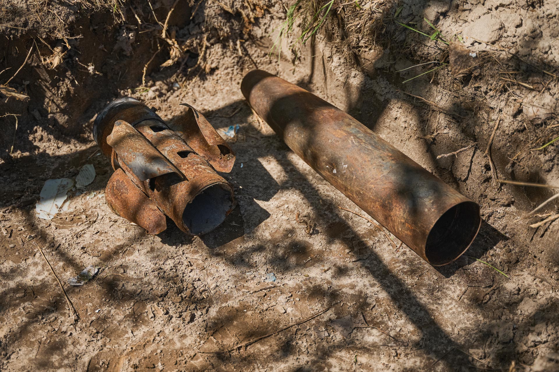Explosive remnants of war uncovered during battle area clearance operations, including corroded rocket and artillery components.